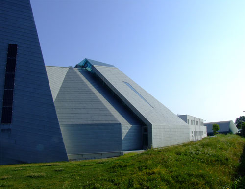 Il manto di copertura, da sud-est; il triangolo segna l'area della sede della presidenza, baricentrica tra i due poli di altare e ambone; in primo piano il campanile
