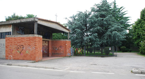La prima chiesa-capannone nella consistenza attuale; a destra, l'ingresso al giardino circostante la chiesa nuova (via Mazzolari angolo via Castellazzo).