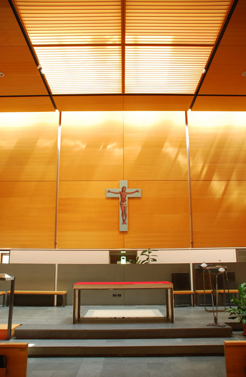 L'altare, il crocifisso e, alle spalle dello schermo di fondo, il tabernacolo riposto nella teca vetrata della cappella eucaristica