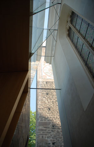 La galleria vetrata di connessione tra la chiesa storica e la nuova aula, presso il campanile romanico, vista dall'interno